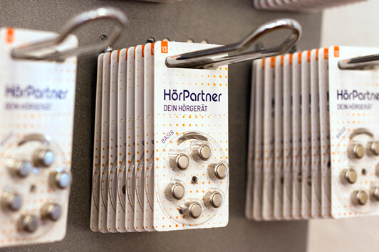 Hörgerätebatterien von HörPartner in Blisterverpackungen hängen ordentlich im Fachgeschäft.